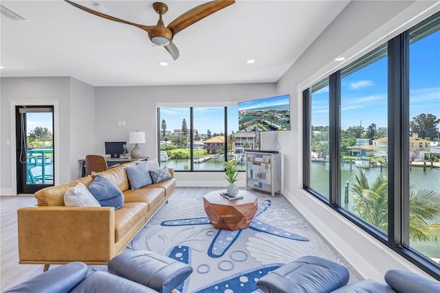 living room with a wealth of natural light, visible vents, ceiling fan, and recessed lighting