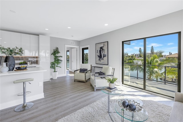 living area featuring light wood finished floors, visible vents, recessed lighting, and baseboards