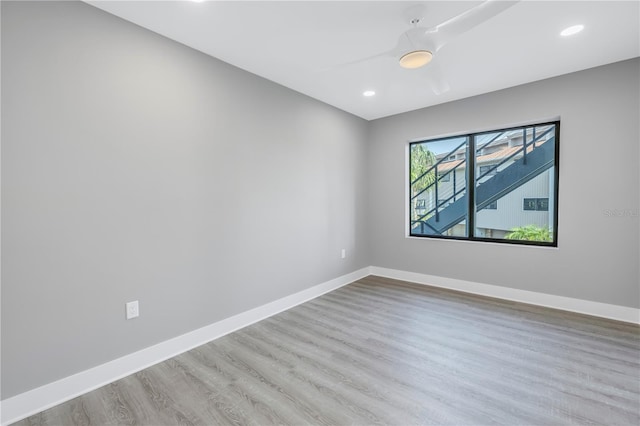 spare room with recessed lighting, baseboards, and wood finished floors