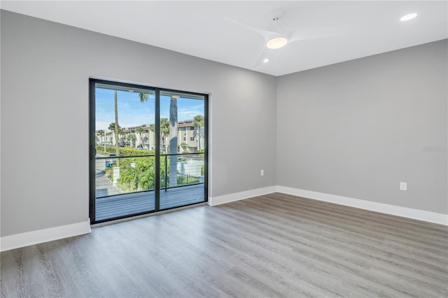 spare room with recessed lighting, wood finished floors, and baseboards