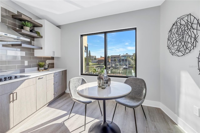 dining space featuring light wood-type flooring and baseboards