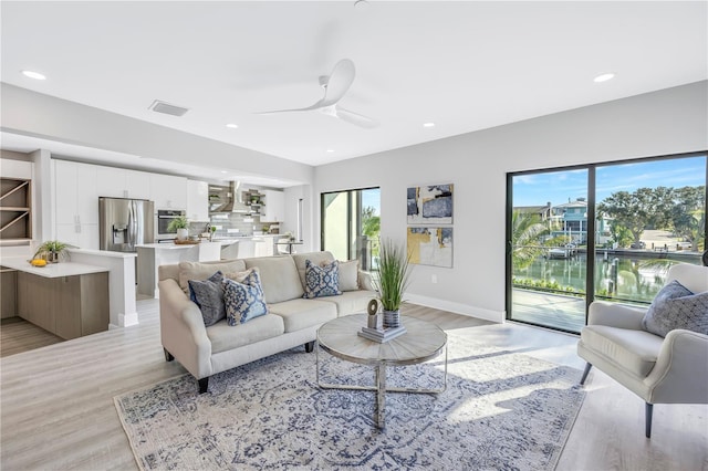 living area with a ceiling fan, baseboards, visible vents, recessed lighting, and light wood-type flooring