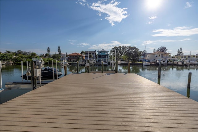 view of dock featuring boat lift, a residential view, and a water view