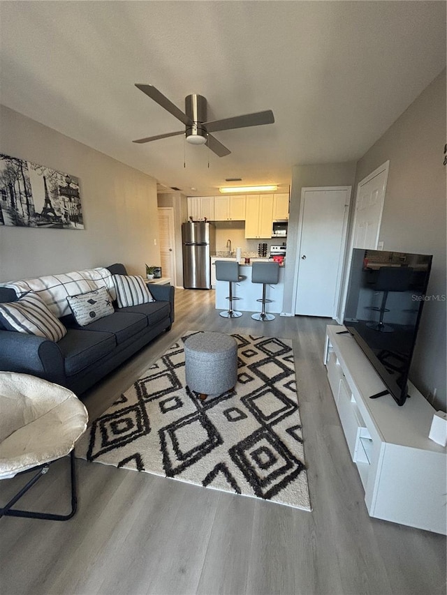 living area featuring ceiling fan and wood finished floors