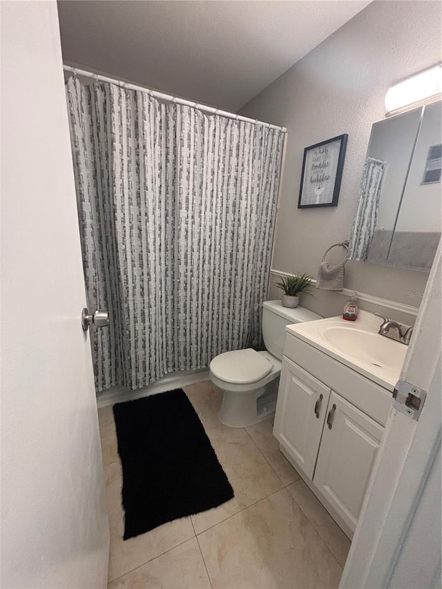 bathroom with vanity, tile patterned floors, toilet, and a shower with shower curtain