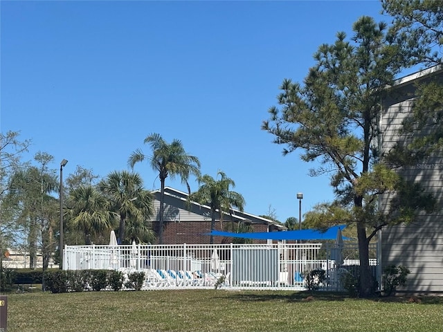 view of pool featuring a yard and fence