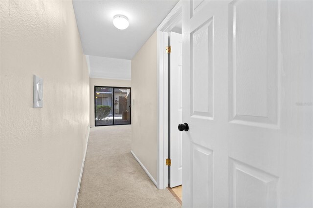 hall with baseboards and carpet floors