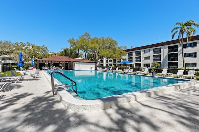 community pool with a patio and fence