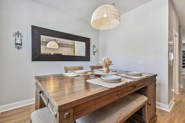 dining area with light wood-style flooring and baseboards