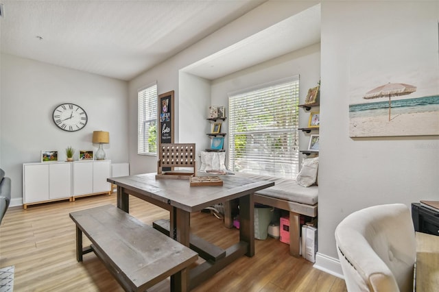 dining area featuring a wealth of natural light, baseboards, and light wood finished floors