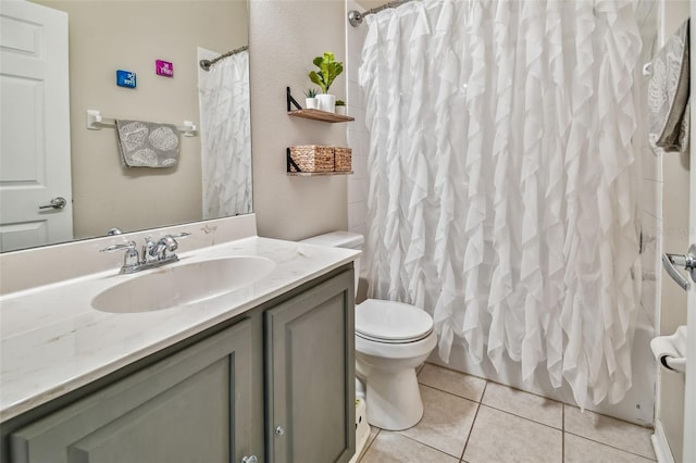 full bathroom featuring tile patterned floors, shower / bathtub combination with curtain, toilet, and vanity