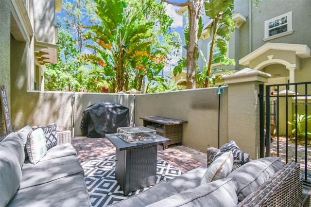 view of patio featuring area for grilling, an outdoor living space with a fire pit, and fence