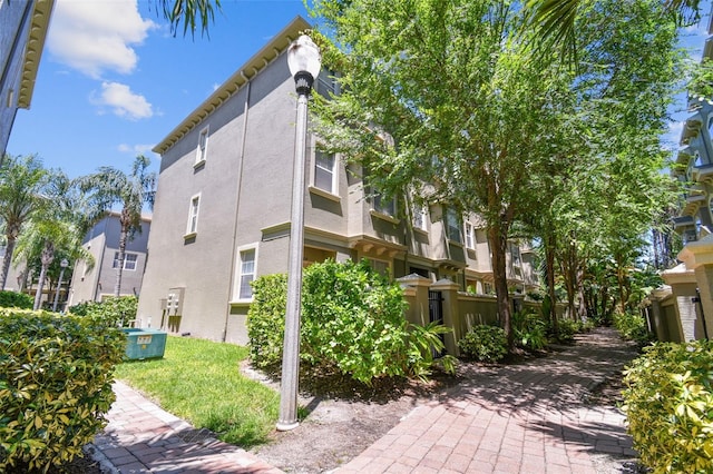 view of side of property featuring stucco siding and central AC unit