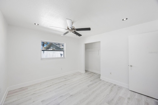 unfurnished bedroom featuring a ceiling fan, recessed lighting, a closet, light wood-style floors, and baseboards