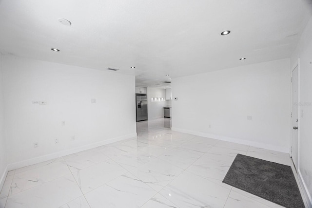 spare room featuring baseboards, visible vents, and marble finish floor