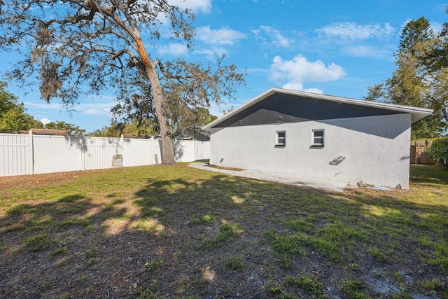 view of home's exterior with a fenced backyard, stucco siding, and a yard