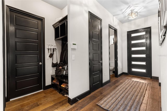 entryway with baseboards and dark wood-type flooring