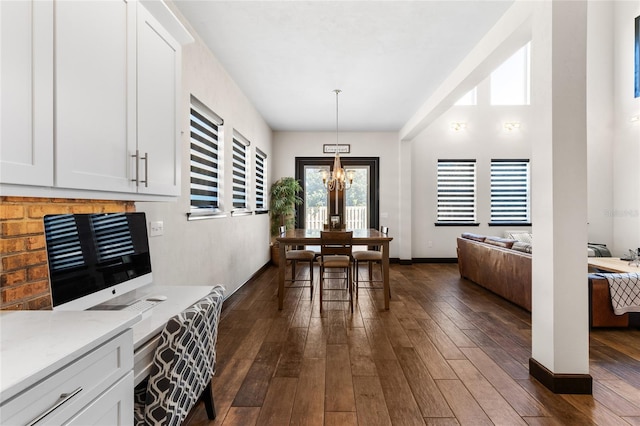 dining room featuring baseboards, an inviting chandelier, and dark wood-style floors