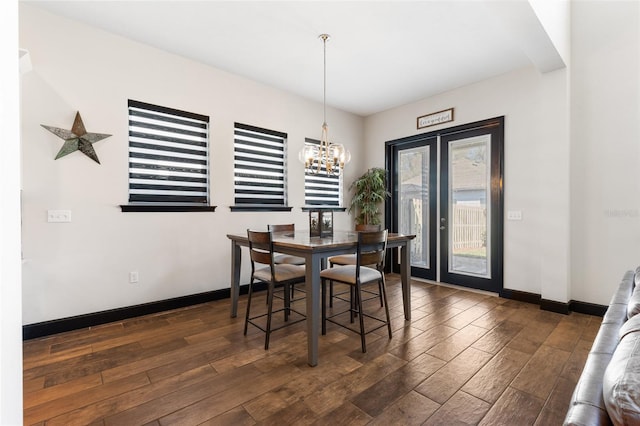 dining room featuring a notable chandelier, wood finished floors, and baseboards