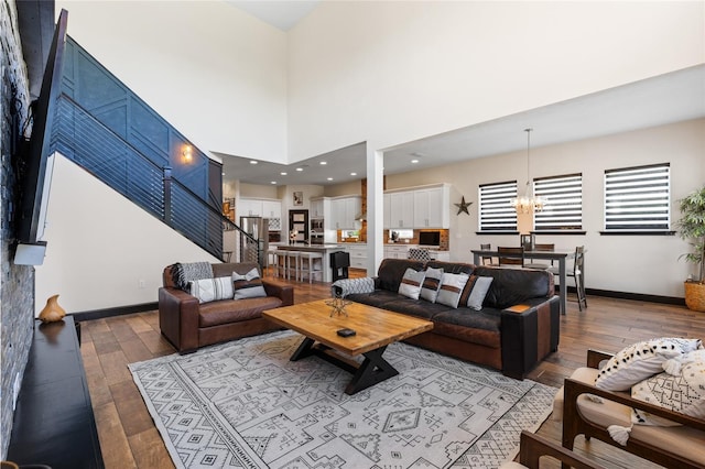 living room with an inviting chandelier, baseboards, and wood-type flooring