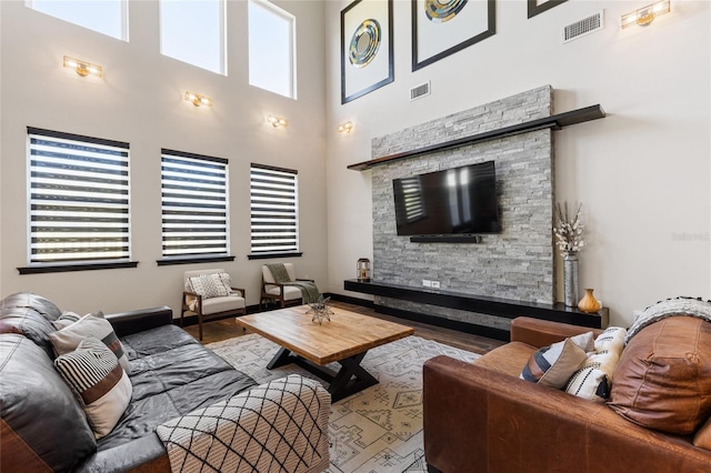 living area with a fireplace, wood finished floors, and visible vents