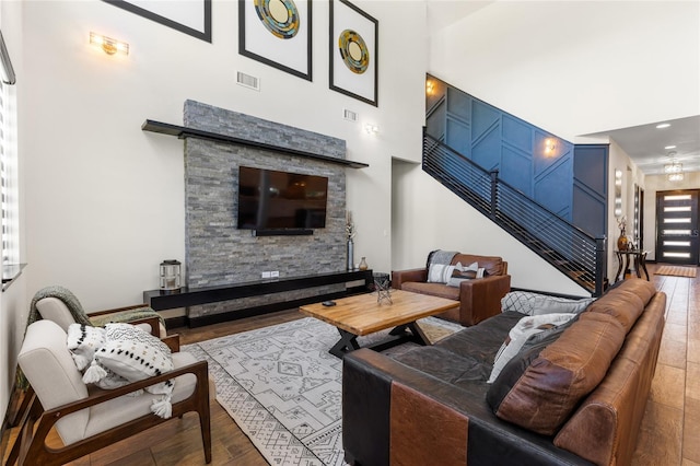 living room with stairway, wood finished floors, and visible vents