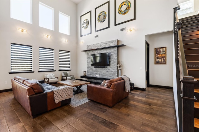 living room with visible vents, stairway, dark wood-type flooring, and baseboards