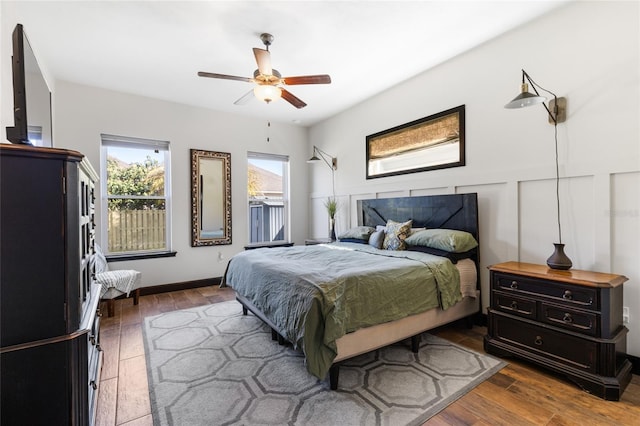 bedroom featuring a decorative wall, ceiling fan, and wood-type flooring