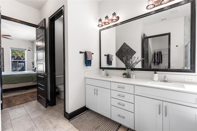 bathroom featuring double vanity, toilet, ensuite bathroom, and a sink