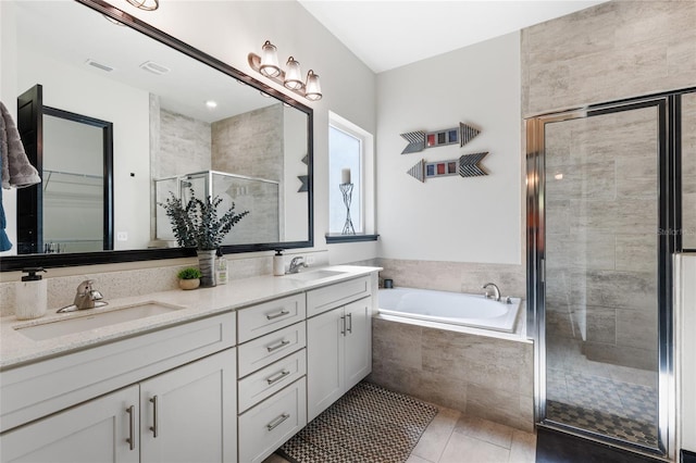 full bathroom with visible vents, a garden tub, a stall shower, a sink, and double vanity