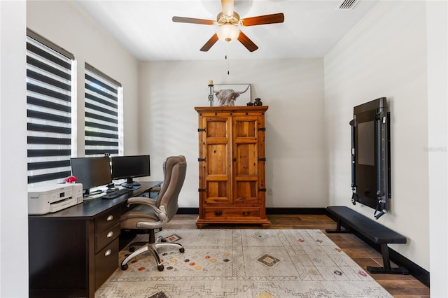 office space featuring wood finished floors, a ceiling fan, baseboards, and visible vents