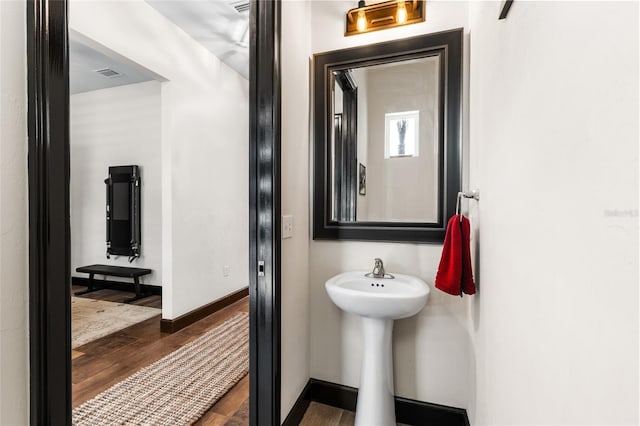 bathroom featuring visible vents, baseboards, and wood finished floors