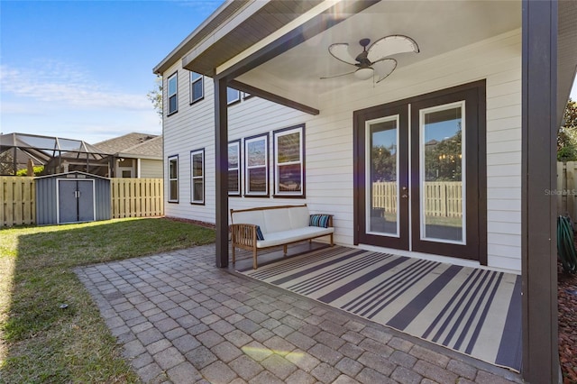 view of patio featuring fence, ceiling fan, an outdoor structure, outdoor lounge area, and a storage shed