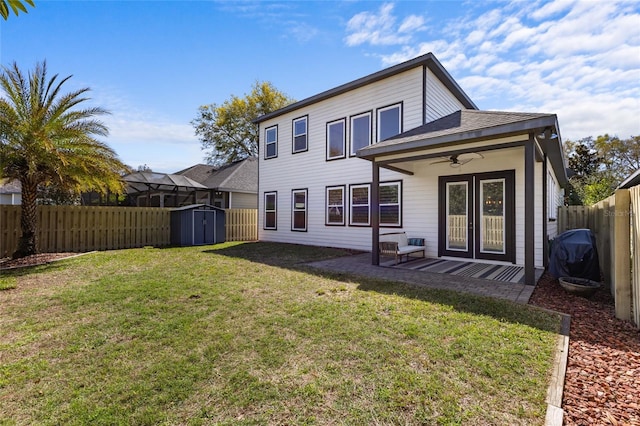 back of property with ceiling fan, a lawn, a fenced backyard, an outdoor structure, and a storage unit