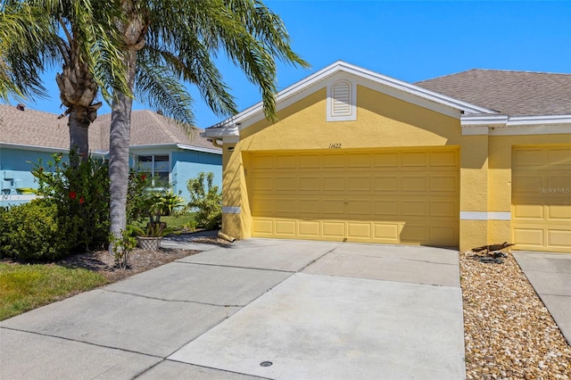 ranch-style house with an attached garage, driveway, and stucco siding