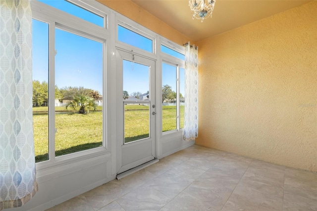 unfurnished sunroom featuring a notable chandelier