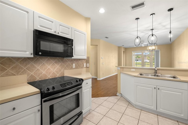 kitchen with visible vents, a sink, stainless steel electric range, black microwave, and decorative backsplash