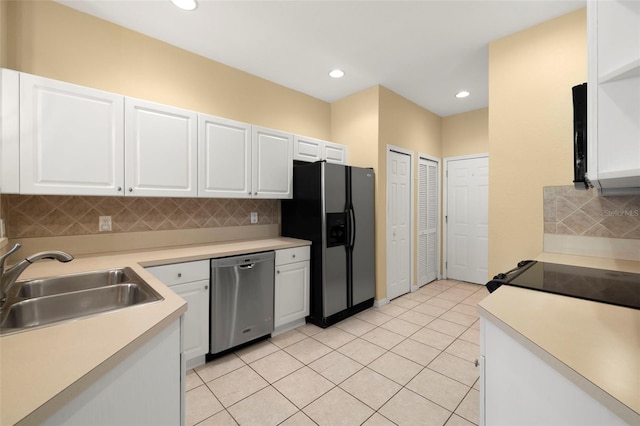 kitchen with backsplash, white cabinetry, stainless steel appliances, and a sink