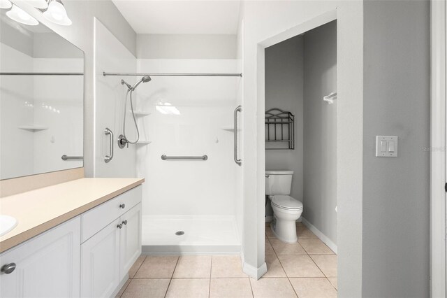 full bathroom featuring tile patterned flooring, toilet, vanity, and walk in shower