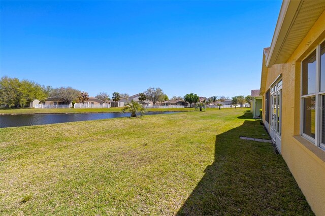 view of yard with a residential view and a water view