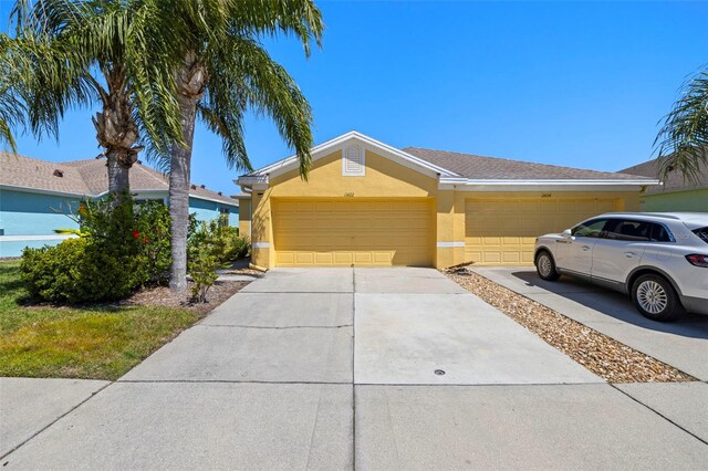 view of front facade featuring stucco siding, concrete driveway, and an attached garage