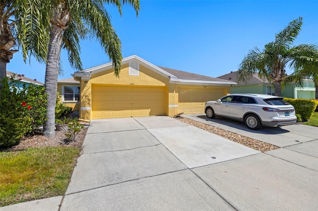 ranch-style house featuring stucco siding, concrete driveway, and an attached garage