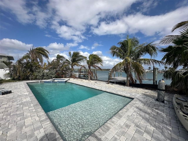 view of swimming pool with a patio area, a water view, and a pool with connected hot tub