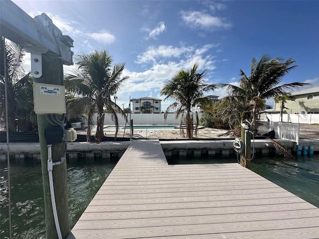 dock area with a community pool and fence