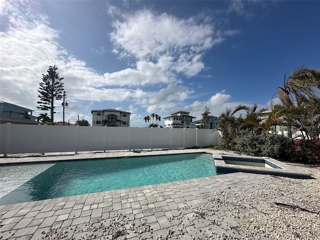 view of pool featuring a patio, a fenced backyard, and a pool with connected hot tub