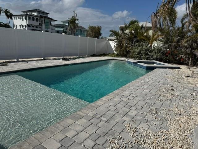 view of pool with a patio area, a fenced backyard, and a pool with connected hot tub