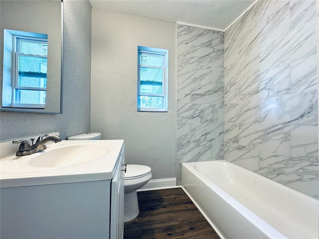 bathroom with toilet, a healthy amount of sunlight, wood finished floors, and a textured wall