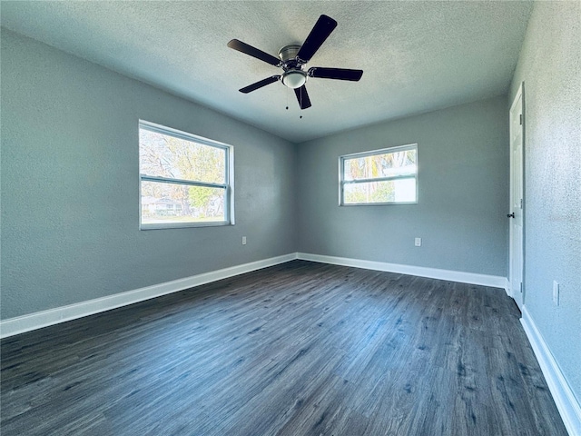 unfurnished bedroom with dark wood-type flooring, baseboards, and a textured ceiling