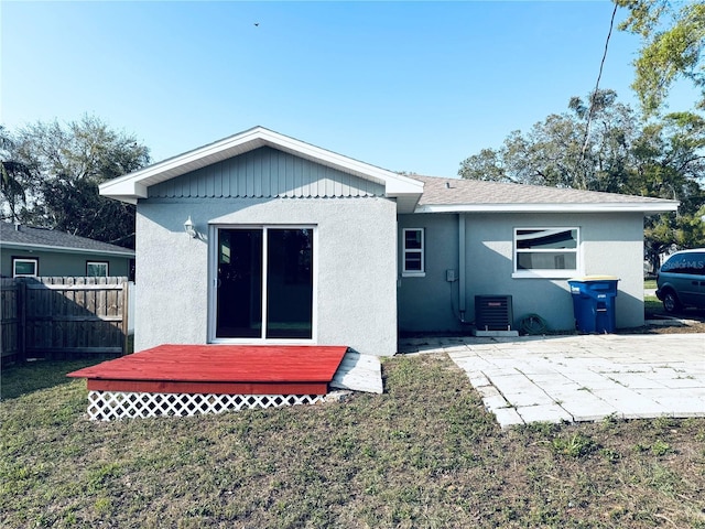 back of house with a yard, stucco siding, a patio, and fence