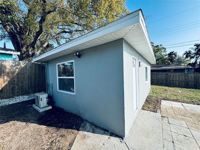 1409 Franklin St, Clearwater, FL 33756 - view of side of property with ac unit, a fenced backyard, and stucco siding